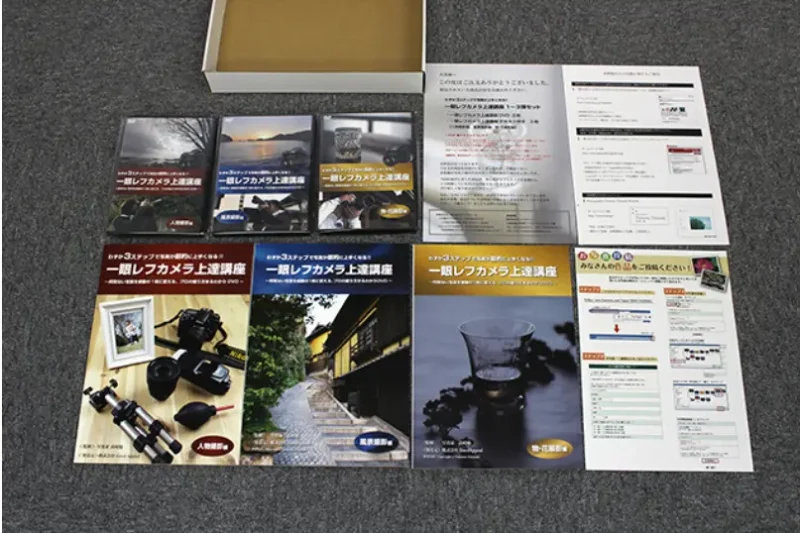 一眼レフ上達講座のDVD3枚とテキスト冊子、各種案内が並んだ同梱内容